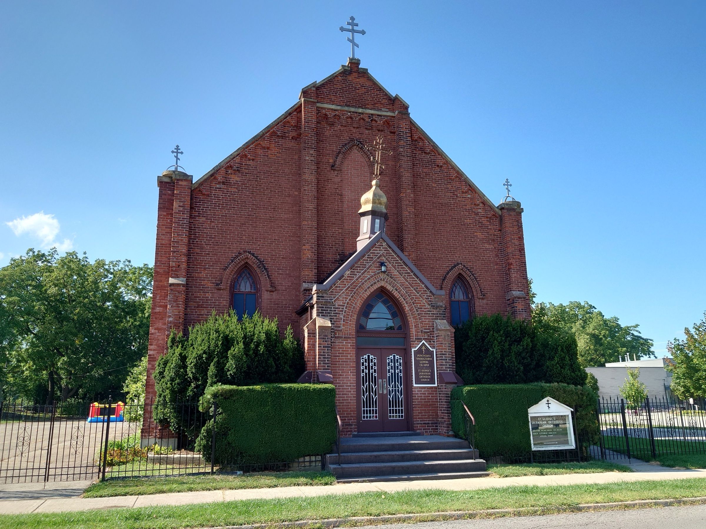 St. George Ukrainian Orthodox Church, a red-brick Gothic church with a small gilded cupola over its arched entrance porch and Orthodox crosses on the gable